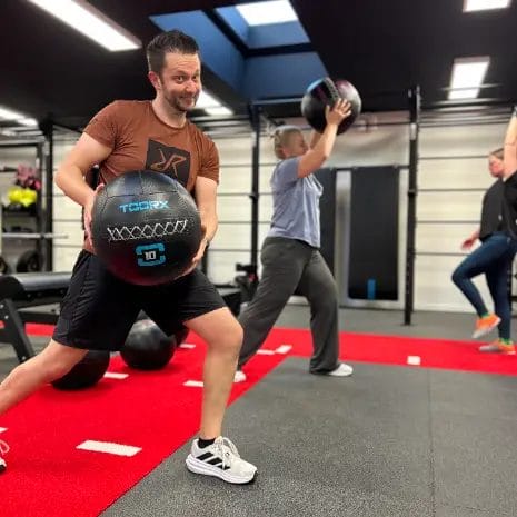 Athlete performing slam ball exercise during functional training at SHARP GYM
