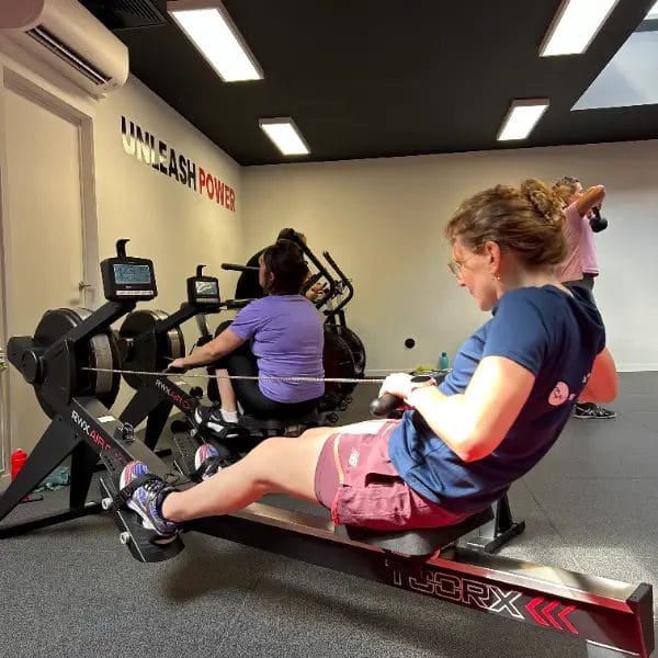 People using rowing machines during workout at SHARP GYM