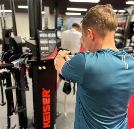 Man performing strength training on cable machine at SHARP GYM