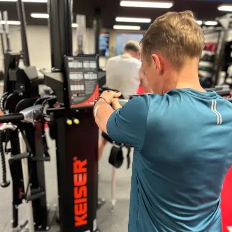 Man performing strength training on cable machine at SHARP GYM